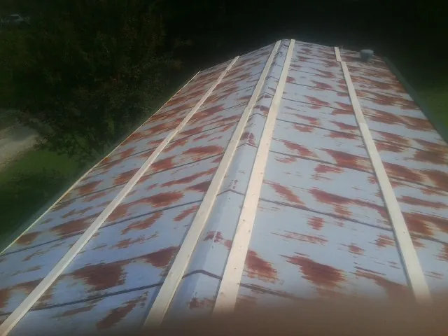 Rusted metal roof panels with new wood purlins before replacement — Storm Damage Roof Repair in Woodside by Roofing Brothers